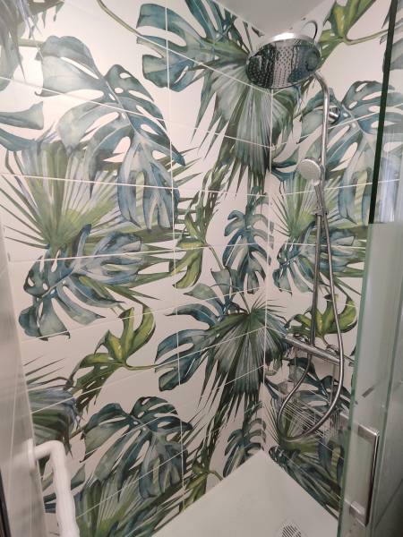 Rénovation complète au grau du Roi à proximité de Montpellier, d’une petite salle de bain a receveur extra plat antidérapant et paroi coulissante, réalisation d’une faïence à motif jungle.